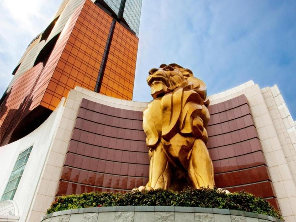 El leon dorado de la entrada del MGM Macau con la torre de fachada ondulada detras